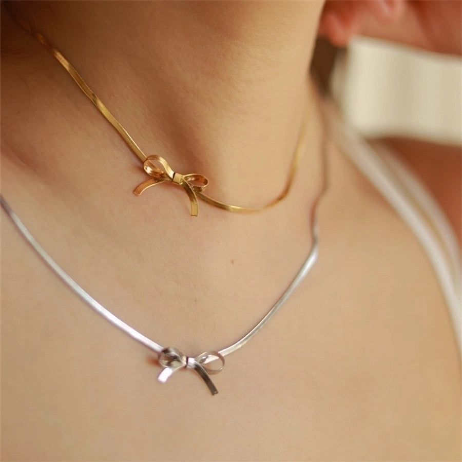 שרשרת Bow — שרשרת נחש חלקה עם תליון פפיון קטן, בגוון זהב ובגוון כסף.